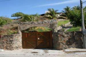 eine große Holztür in einer Steinmauer in der Unterkunft Villa Duna Icaraizinho beach front in Icaraí