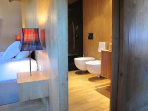 a bathroom with a bed and a toilet and a lamp at Casa do Talasnal in Lousã