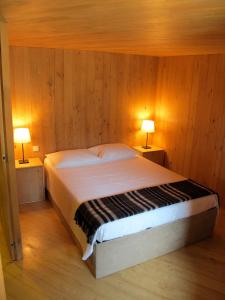 a bedroom with a bed with two lamps on two tables at Casa do Talasnal in Lousã