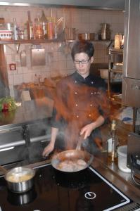 um homem a cozinhar comida numa panela numa cozinha em Hotel Restaurant Ölmühle em Landstuhl