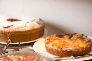 - une table avec 2 gâteaux et un bol de fruits dans l'établissement Hotel Spadari Al Duomo, à Milan