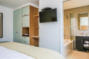 a bedroom with a tv on top of a refrigerator at Ocean Vista Boutique Guest House in Durban