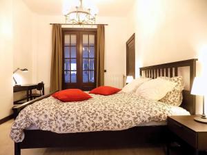 um quarto com uma cama com duas almofadas vermelhas em Maison Roosevelt - Charleroi Airport - Ideal Families em Charleroi