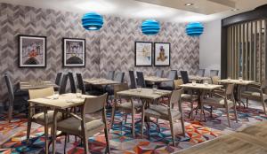 a dining room with tables and chairs and blue lights at Leonardo Hotel Southampton in Southampton