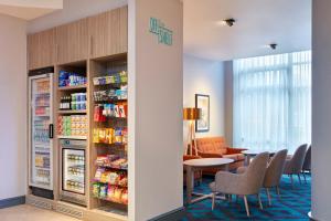 a restaurant with a refrigerator and a table and chairs at Leonardo Hotel Southampton in Southampton