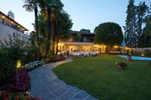 un patio trasero con piscina y un complejo en Hotel Ascovilla Charming Hideway, en Ascona