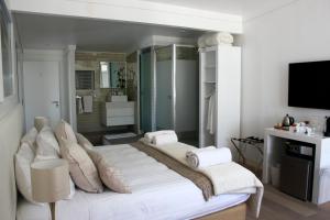 een slaapkamer met 2 bedden en een televisie. bij Swakopmund Luxury Suites in Swakopmund