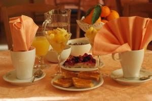 a table with plates of food and glasses of orange juice at Hotel Adria in Bari