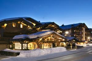 um alojamento de esqui na neve à noite em Guarda Golf Hotel & Residences em Crans-Montana