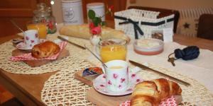 uma mesa com um pequeno-almoço de croissants e sumo de laranja em Ô de mer - à 20m de la plage em Sangatte