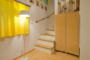 a room with stairs and a yellow curtain and a lamp at Lucy's House横浜中華街 House1 in Yokohama