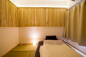 a small room with a bed and a curtain at Lucy's House横浜中華街 House1 in Yokohama