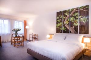 a bedroom with a bed and a large painting on the wall at Hotel Sagitta in Geneva