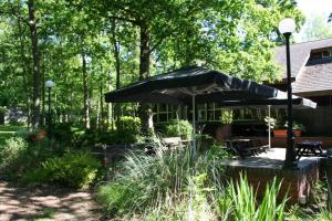 a patio with a table and an umbrella at Marwell Hotel - A Bespoke Hotel in Winchester