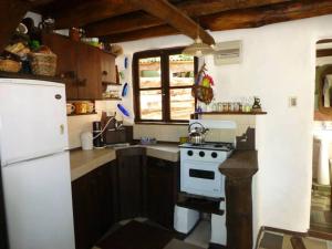 cocina con fogones y nevera blanca en Casita de Duendes, en Salinas