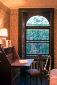 een bureau in een kamer met een raam en een bureau met een stoel bij The Harlem Flophouse in New York