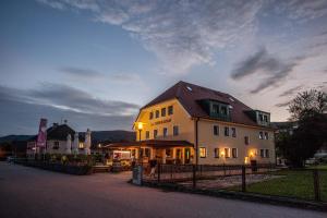 een groot huis met een hek ervoor bij Hotel Garni Weinquadrat in Weissenkirchen in der Wachau