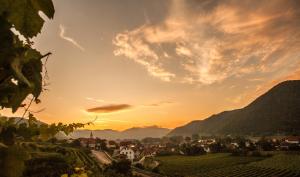 uitzicht op een stad bij zonsondergang met bergen bij Hotel Garni Weinquadrat in Weissenkirchen in der Wachau