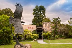 uma estátua de uma águia em frente a um edifício em Tsala Treetop Lodge em Plettenberg Bay