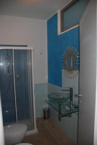 a bathroom with a glass shower and a sink at La Rosa dei Venti Resort in Piombino