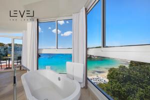 uma casa de banho com uma banheira branca e janelas amplas em Meliá Cala Galdana em Cala Galdana