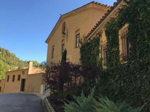 un bâtiment avec du lierre sur son côté dans l'établissement Montserrat La Calsina, à Monistrol de Montserrat