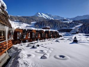 皮拉TH Pila的一座被雪覆盖的建筑,背景是群山