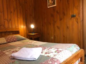 een slaapkamer met een bed met een witte handdoek erop bij Hostal el Nogal Pucón in Pucón