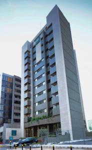 een hoog gebouw met een auto ervoor geparkeerd bij Citea Apart Hotel in Beiroet