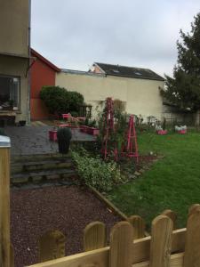 une arrière-cour avec un jardin clôturé et une maison dans l'établissement La Vie est Belle, à Abbeville