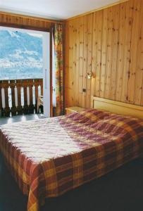 - une chambre avec un lit et une grande fenêtre dans l'établissement Edelweiss, à Samoëns