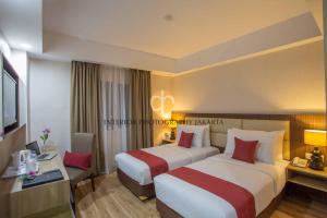 A bed or beds in a room at Orchardz Hotel Bandara