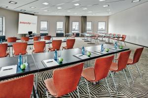 a large meeting room with a long table and chairs at IntercityHotel Mainz in Mainz