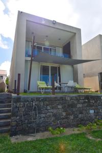 uma casa com uma parede de pedra e uma mesa e cadeiras em Turquoise Bay Beach Apartments Trou d'Eau Douce em Trou dʼ Eau Douce