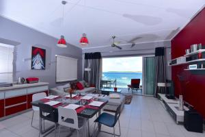 uma cozinha e sala de estar com mesa e cadeiras em Turquoise Bay Beach Apartments Trou d'Eau Douce em Trou dʼ Eau Douce