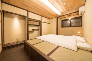 ein Schlafzimmer mit einem großen Bett in einem Zimmer in der Unterkunft Kyoto style small inn Iru in Kyoto