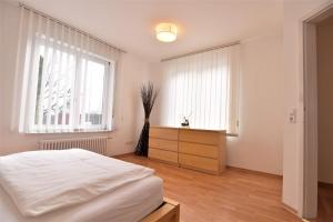 a bedroom with a bed and a dresser and a window at Apartment D&D Spessart in Ettlingen