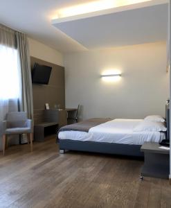 Dormitorio con cama, escritorio y TV en Hotel Di Varese, en Varese