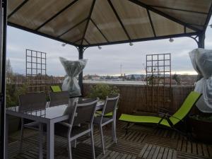 eine Terrasse mit einem Tisch und Stühlen auf einer Terrasse in der Unterkunft Datcha Bourguignonne Beaune in Beaune