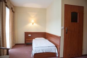 Kleines Zimmer mit einem Bett und einer Tür in der Unterkunft Hotel Przedwiośnie in Masłów