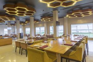 une grande salle à manger avec des tables et des chaises dans l'établissement Hotel Naveen Lakeside, à Hubli