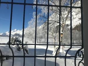 Blick auf einen schneebedeckten Berg durch ein Fenster in der Unterkunft Chesa Suot Ovas in Sils Maria