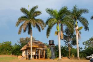 een klein huis met palmbomen ernaast bij Living Waters Resort in Jinja