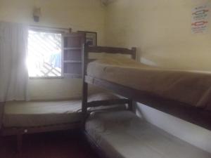 2 beliches num quarto com uma janela em Hostel Ibirapita em La Paloma