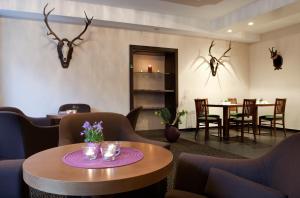 une chambre avec une table, des chaises et des bois sur le mur dans l'établissement AKTIVHOTEL Weisser Hirsch, à Mariazell