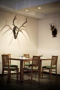 une salle à manger avec une table et quelques bois sur le mur dans l'établissement AKTIVHOTEL Weisser Hirsch, à Mariazell