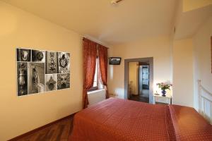 Un dormitorio con una cama roja con posters en la pared en Hotel Villa San Michele, en Carmignano