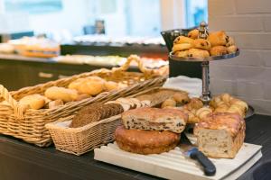 einen Tisch mit verschiedenen Brotsorten und Gebäck in der Unterkunft Hotel Zeerust Texel in De Koog