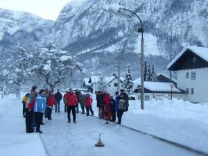 Un groupe de personnes marchant dans une rue enneigée dans l'établissement Dormio Gasthof Höllwirt, à Obertraun