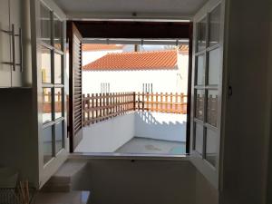 z otwartym oknem z widokiem na balkon w obiekcie Casa da Vila w mieście Vila Nova da Barquinha